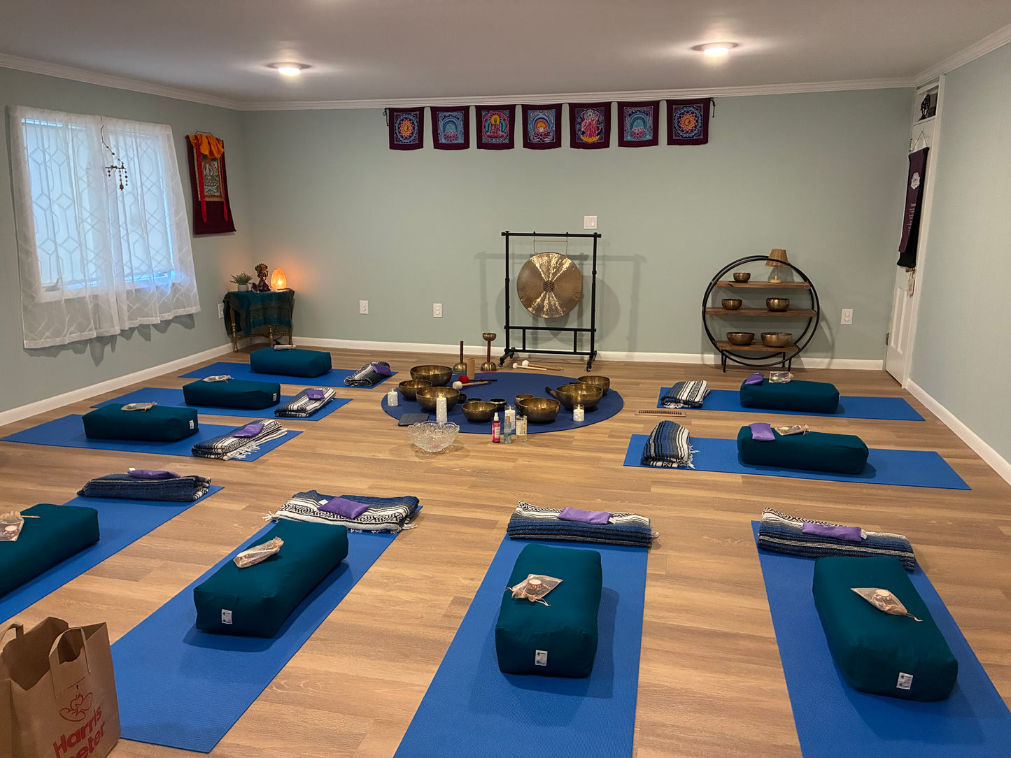 Yoga studio with mats, bolsters, singing bowls, and a gong set up for sound healing session